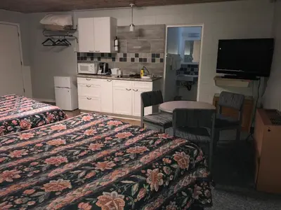 a hotel room with two beds and a kitchen at Kootenay Country Inn in Cranbrook