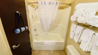a bathroom with a tub and white towels at Ramada by Wyndham Westlock in Westlock