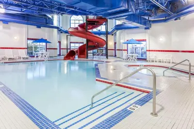 a swimming pool with a red slide in it at Ramada by Wyndham Westlock in Westlock