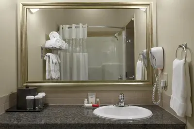 a bathroom with a sink and a mirror at Ramada by Wyndham Westlock in Westlock