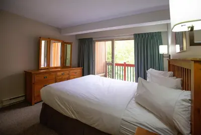 a bedroom with a large white bed and a window at Panorama Vacation Retreat at Horsethief Lodge in Panorama