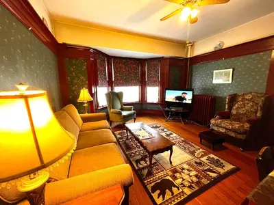 a living room with a couch and a tv at Arundel Mansions Hotel in New Westminster