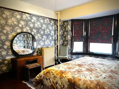 a bedroom with a bed and a mirror at Arundel Mansions Hotel in New Westminster