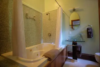 a bathroom with a tub and a shower and a sink at Wedgwood Manor and Glamping Retreat in Crawford Bay