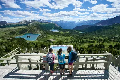 a group of children standing on top of a viewing platform at Sunshine Mountain Lodge in Banff