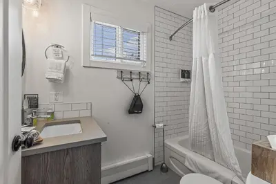 a white bathroom with a sink and a shower at Lamphouse By Basecamp in Canmore