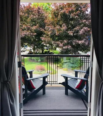 a view of a porch with benches and trees at Artisan Suites on Bowen in Bowen Island