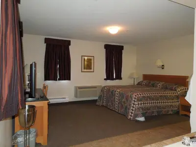 a hotel room with a bed and a television at Walking Eagle Inn & Lodge in Rocky Mountain House