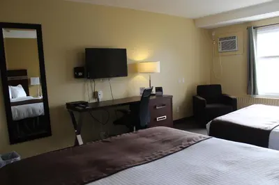 a hotel room with a desk and a bed and a mirror at Walking Eagle Inn & Lodge in Rocky Mountain House