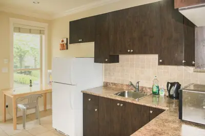 a kitchen with a white refrigerator and a sink at Imperial House in Burnaby