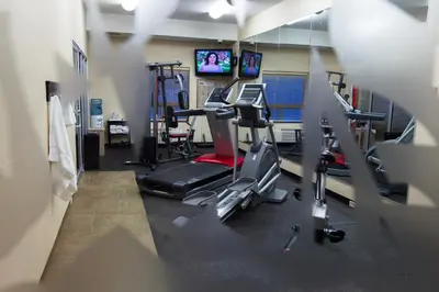 a gym with cardio equipment and a tv in a room at The Kanata Fort Saskatchewan in Fort Saskatchewan