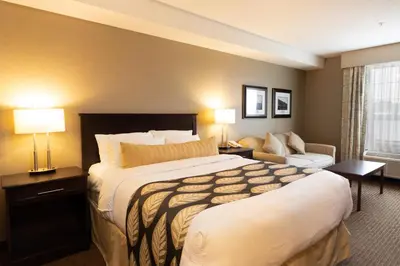 a hotel room with a large bed and a couch at The Kanata Fort Saskatchewan in Fort Saskatchewan