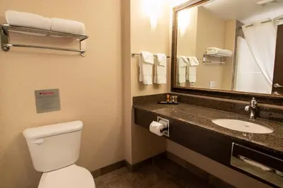 a bathroom with a toilet and a sink and a mirror at The Kanata Fort Saskatchewan in Fort Saskatchewan