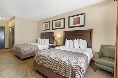 a hotel room with two beds and a chair at Best Western Plus St Albert in St. Albert
