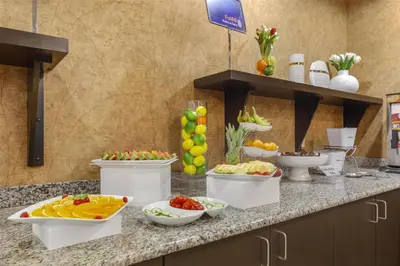 a buffet with fruits and vegetables in bowls on a counter at Best Western Wainwright Inn & Suites in Wainwright