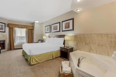 a hotel room with a bed and a bath tub at Best Western Wainwright Inn & Suites in Wainwright