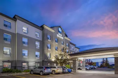 a hotel with cars parked in a parking lot at Best Western Wainwright Inn & Suites in Wainwright