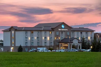 a hotel with cars parked in front of it at Best Western Rocky Mountain House Inn & Suites in Rocky Mountain House