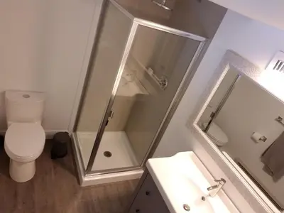 a bathroom with a shower and a toilet and a sink at City Gardens Suites B&B in North Vancouver