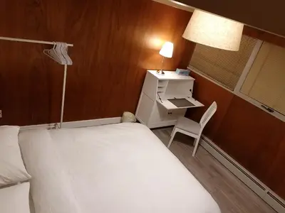 a bedroom with a bed and a desk and a chair at City Gardens Suites B&B in North Vancouver