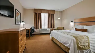 a hotel room with a bed and a desk at Best Western Plus Chateau Inn Sylvan Lake in Sylvan Lake