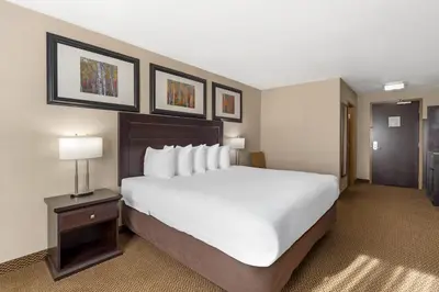 a hotel room with a large bed and a door at Best Western Bonnyville Inn & Suites in Bonnyville