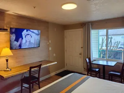 a bedroom with a bed and a tv on the wall at Harbour Light Motel in Nanaimo