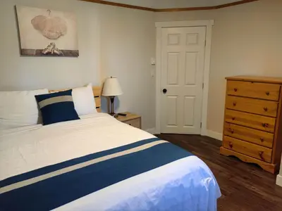 a bedroom with a bed with a blue and white bedspread at Harbour Light Motel in Nanaimo