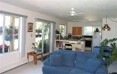 a living room with a blue couch and a kitchen at Island View B&B in Nanaimo