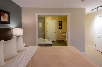 a bedroom with a bed and a bathroom with a tub at Painted Boat Resort Spa and Marina in Madeira Park