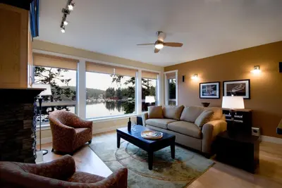 a living room with a couch and a fireplace at Painted Boat Resort Spa and Marina in Madeira Park