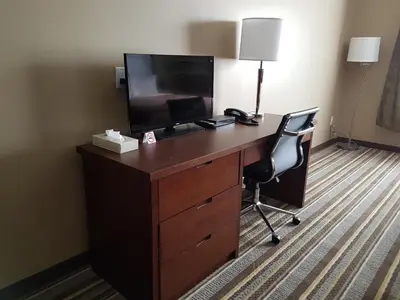 a desk with a television and a chair in a hotel room at Super 8 by Wyndham Hardisty in Hardisty