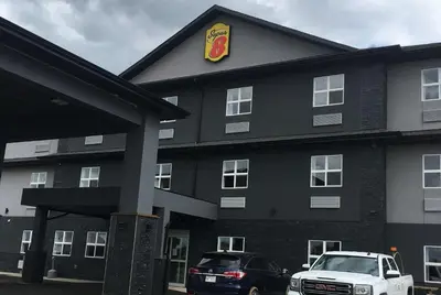 a black building with a car parked in front of it at Super 8 by Wyndham Hardisty in Hardisty