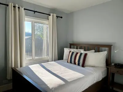 a bed in a bedroom with a window at Buccaneer Inn in Nanaimo