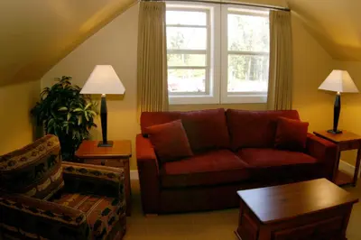 a living room with a red couch and a window at Oceanside Village Resort in Parksville