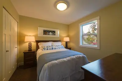 a bedroom with a bed with two lamps and a window at Oceanside Village Resort in Parksville