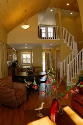 a living room with a staircase and a vase with flowers at Oceanside Village Resort in Parksville