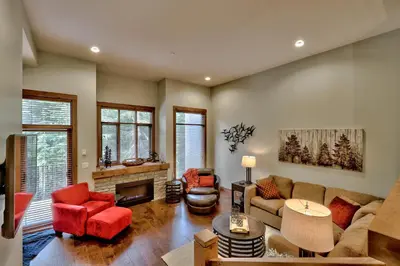 a living room with red furniture and a fireplace at 17 Village Walk Sun Peaks BC in Sun Peaks