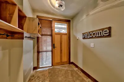a hallway with a door and a sign that reads welcome at 17 Village Walk Sun Peaks BC in Sun Peaks