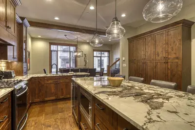 a kitchen with wooden cabinets and a large marble counter top at 17 Village Walk Sun Peaks BC in Sun Peaks