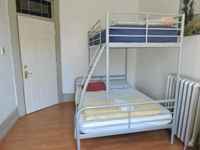 a bunk bed in a room with a ladder at St Clair Hostel in Vancouver
