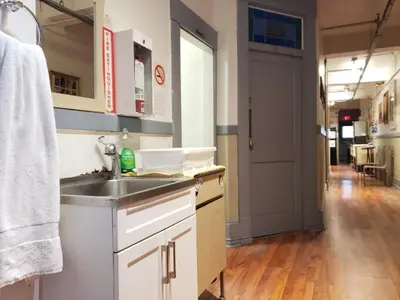 a kitchen with a sink and a hallway at St Clair Hostel in Vancouver