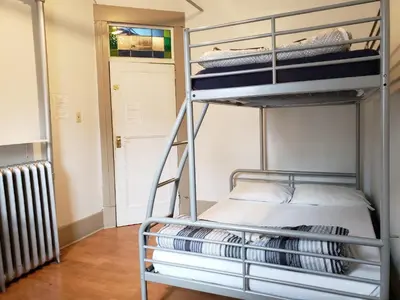 a metal bunk bed in a room with a radiator at St Clair Hostel in Vancouver