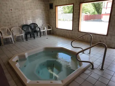 a jacuzzi tub in a room with chairs at Falcon Resort in Osoyoos