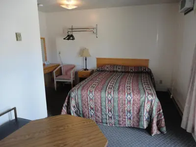 a hotel room with a bed and a desk at Falcon Resort in Osoyoos