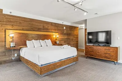 a bedroom with a bed and a flat screen tv at Basecamp Lodge Canmore in Canmore