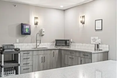 a kitchen with a sink and a microwave at Basecamp Lodge Canmore in Canmore