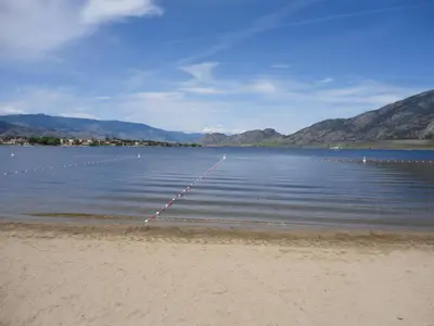 a large body of water with mountains in the background at Spanish Fiesta Resort in Osoyoos