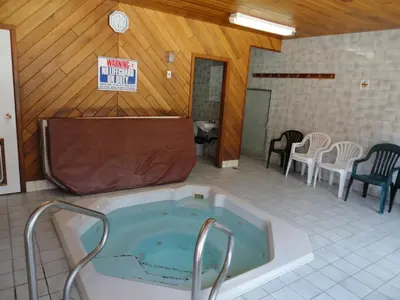 a bath tub in a room with a table and chairs at Spanish Fiesta Resort in Osoyoos
