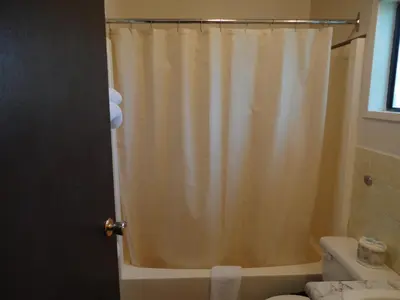 a bathroom with a shower curtain and a toilet at Spanish Fiesta Resort in Osoyoos